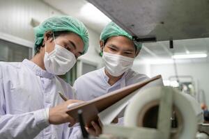 quality team or food or beverages technician change parameter and condition control food or beverages before send product to the customer. Production leader recheck machine and productivity photo