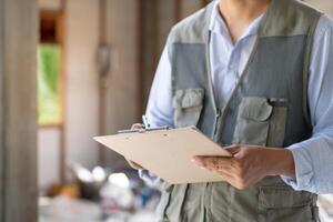 inspector or engineer is inspecting construction and quality assurance new house using a checklist. Engineers or architects or contactor work photo