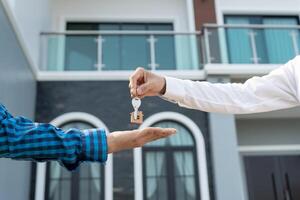 rental and selling home, Real estate agent manager smile holding key for new owner. rent house, Sales, loan credit financial, insurance, Seller, dealer, installment, buy, sell, move in photo