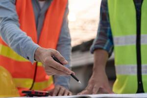 inspector or engineer is inspecting construction and quality assurance new house using a blue print. Engineer or architects or contactor work to build the house photo