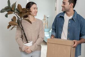 Moving house, relocation. Couples hold carton box contain equipment for new condominium, inside the room was a cardboard box containing personal belongings and furniture. move in the apartment. photo
