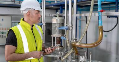 Engineers or utility staff wearing safety helmet fix the machines in the production line. Utility inspector check machine and test the system to meet the standard. machine. Preventive Maintenance. photo