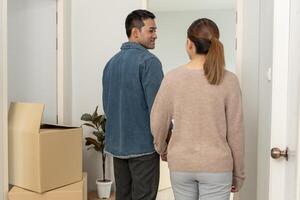 Moving house, relocation. Couple hold hand and open a new house, inside the room was a cardboard box contain personal belongings. move in the new apartment or condominium. smile Couple photo