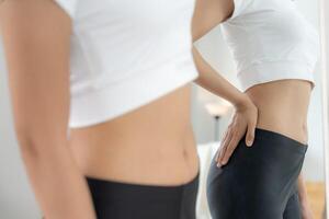 Women show result of diet. Beautiful shape. female look mirror for check shape body have a reduced waist size after under going a weight loss corse. balance, control, routines, exercise. photo