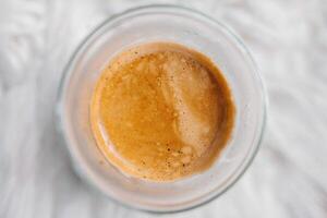 An espresso cup with a brown liquid in it photo