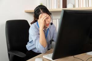 Stressed Customer Service Agent. Female representative showing frustration while dealing with client issues. photo