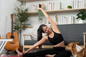 Home Fitness and Stretching. Woman engaging in yoga poses with her dog by her side. photo