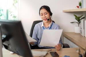 Remote Work and Document Management. Woman reviewing papers while providing customer support. photo