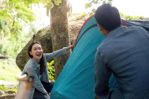 Couple Setting Up Tent Together While Camping in Nature photo