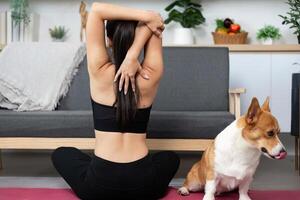 Mindfulness and Stretching. Woman practicing yoga with her dog in a serene home environment. photo