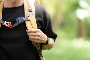 Close-up of Hiker Adjusting Backpack Strap in Nature. photo