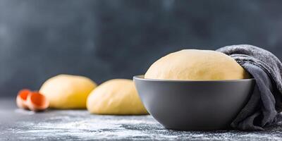 Bowl of Yeast Dough with Flour and Two Dough Balls photo