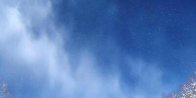 Snowy Sky with Blue Clouds and Falling Snowflakes photo