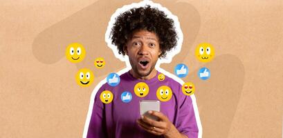 Shocked African American guy with curly hair using smartphone, engaging in messaging. Colorful emojis float around them, indicating interaction and excitement about social media. photo