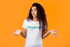 Who Cares. Puzzled Female Volunteer Shrugging Shoulders Posing Looking At Camera Standing In Studio On Yellow Background. Portrait Of Clueless Activist Woman, I Don't Know Concept photo