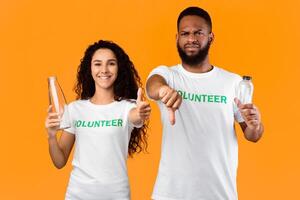 Don't Use Plastic. Two Mixed Volunteers Holding Glass And Plastic Bottles Gesturing Like And Dislike Disapproving Usage Of Single-Used Bottle Standing Over Yellow Studio Background photo