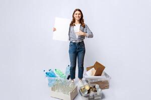 A woman stands confidently, showcasing her commitment to recycling. She is surrounded by organized containers of various recyclable materials, emphasizing environmental awareness and responsibility. photo