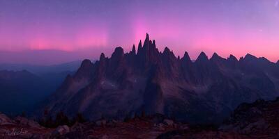 Majestic Mountain Range at Dusk with Pink Aurora Borealis photo