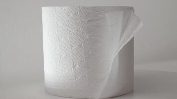 Close-up of a rotating roll of soft toilet paper on a white background. Double-layer toilet paper. The concept of hygiene, cleanliness and care video