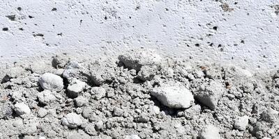 Grey Construction Debris Pile Near White Wall Building Material Texture photo