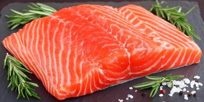 Fresh Salmon Fillet with Rosemary and Seasoning on Dark Stone Plate photo