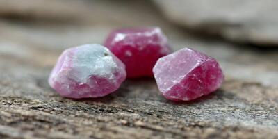 Three Pink Ruby Crystals on Wood Background Closeup Photography photo