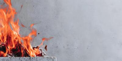 Burning Embers in Concrete Container Bright Orange Flames Fire Closeup photo