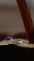 Dark beer stream pouring into glass with golden foam video