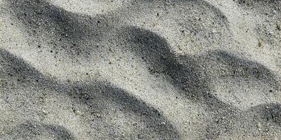 Detailed Close Up of Light Beige Sand with Darker Wave Patterns Beach Sand Texture photo