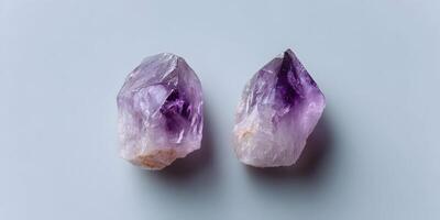 Two Amethyst Crystal Clusters on Light Gray Background photo