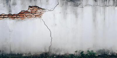 Old Weathered White Wall with Exposed Red Brick and Cracks photo
