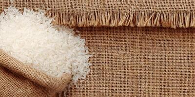 White Rice in Burlap Sack on Burlap Background Food Grain Texture photo