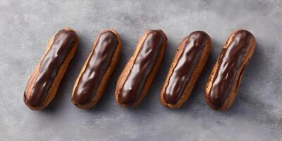 Five Chocolate Eclairs in a Row on Gray Background Gourmet Pastry Dessert Food Photography photo