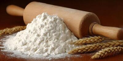 Wooden Rolling Pin and Pile of White Flour with Wheat photo