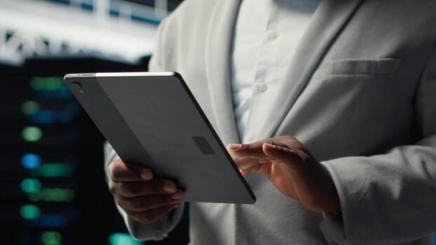 cerca arriba de sistema administrador caminando en datos centro, utilizando tableta a cheque engranaje para sistema estabilidad. eso especialista supervisando servidor centro, utilizando dispositivo a configurar plataformas, optimizando actuación foto