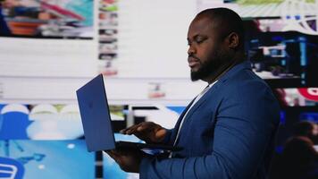 afrikansk amerikan man på bärbar dator nedsänkt i en värld av uppkopplad innehåll, representerar de framtida av social samspel, ai drivs plattformar och modern digital upplevelser. användare gränssnitt. kamera b. video