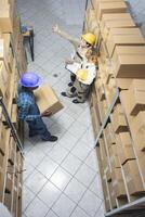 Multiethnic group of workers perform operational tasks in a depot, clean and structured factory space. Stacked boxes to handle the logistics chain, manual work unit in warehouse. photo