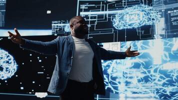 Black IT technician hosting a live presentation for artificial intelligence systems, offering insight on predictive analytics and automation. Male public speaker at AI convention. Camera B. video