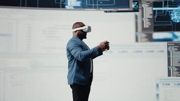African American programmer engaging in virtual reality with a headset, focusing on system development. Utilizing code on terminal window to debug and design new software. IT career. Camera A. video