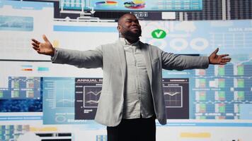 Young black administrator leads visionary business pitch at event, inspiring the audience to increase performance metrics. Businessman public speaker doing a speech at the convention. Camera A. video
