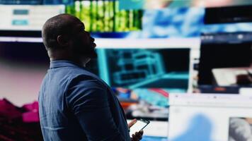 africano americano experto explorador tecnología impulsado ambiente con visual datos, contenido alimenta y aplicaciones simbolizando entretenimiento, social alcanzar y digital transformación. cámara b. video