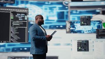 africano americano desenvolvedor trabalhando em programação e automação, codificação em uma computador portátil com uma futurista interface atrás ele. tecnologia profissional prospera dentro uma mundo do ai e código trechos. Câmera uma. video
