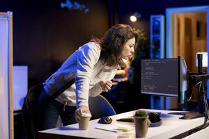 System administrator with disposable cup of coffee entering office to implement security measures, protecting company systems and data. IT expert starting job shift with hot beverage, testing code photo