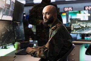 Intelligence corps agent working in command center housing operational missile defense system designed to intercept ballistic rockets. Middle Eastern man tracking missiles using radar systems photo