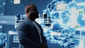 afrikanisch amerikanisch Kerl Bewertungen Clever Technik ai Systeme zu interagieren mit kybernetisch Plattformen und ai Schnittstellen, Darstellen das Integration von Maschine Lernen und vorausschauend Analytik. Kamera b. video