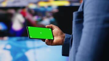 African american user holding a phone with isolated mockup display, digital system of networks and apps on dashboard. Highlighting the integration of AI and fintech. Multitasking. Camera B. video
