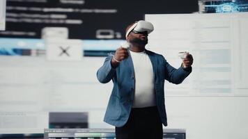 African american software developer uses virtual reality headset for coding, high tech interface workspace. Surrounded by terminal windows, representing digital programming culture. Camera A. video
