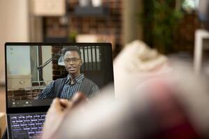 Remote worker speaks with company manager on call, discussing tasks and responsibilities of working from home. African american businessmen comparing marketing strategies during virtual meeting. photo