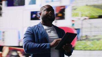 Black social media manager browses high tech environment with app icons, infographics and social networking feeds. Examining social big data on web platforms, digital influence. Camera B. video