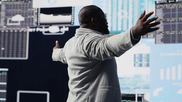 svart ledare använder sig av digital grafer och analys till förbättra finansiera modeller för givande förvaltning beslut. professionell kille optimerande prestanda med tech intelligens, fintech. kamera b. video